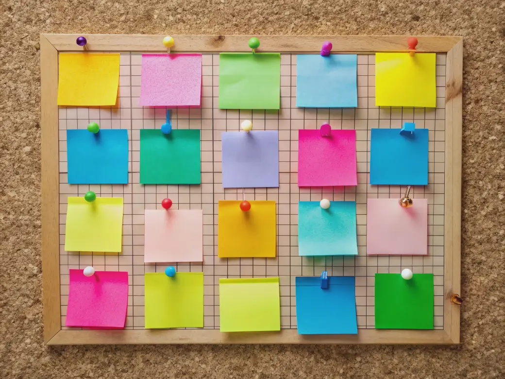 Colorful sticky notes pinned to a grid board – A Guide to College Application Deadlines by Opus College Prep.